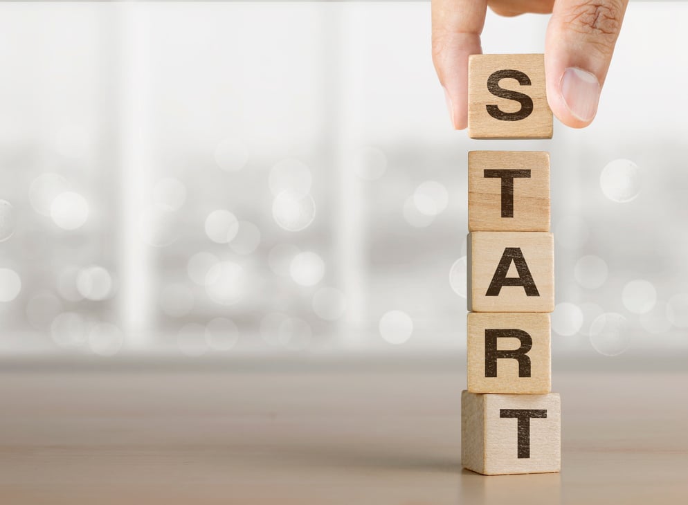 Hand arranging wooden blocks with the word START. Start, Start up, new career or new business, mindset concept.